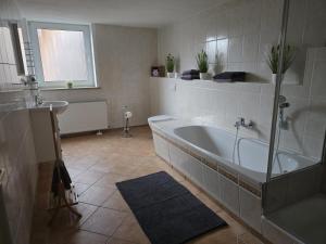 a bathroom with a bath tub and a sink at Apartment Schneider in Höxter