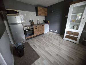 a kitchen with a white refrigerator and wooden floors at Apartment Schneider in Höxter