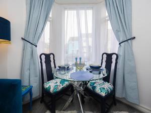 a dining room table with two chairs and a window at Reverie Escape by Halisi in Ramsgate
