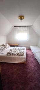 a bedroom with two beds and a window at Hattyú Vendégház in Gárdony
