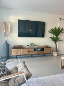 a living room with a television on a wall at Ben's Gem in Philipsburg
