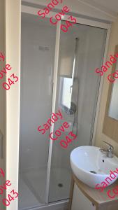 a bathroom with a white sink and a shower at Sandy cove 043 in Barmouth