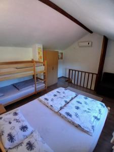 a bedroom with two bunk beds and a couch at Kuća za odmor Buk in Čapljina