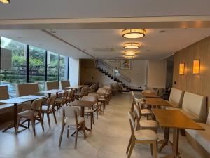 a row of tables and chairs in a restaurant at Hotel Plaza Belmar by HCC in Campo Grande