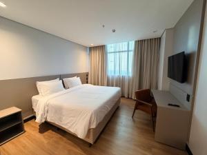 a hotel room with a bed and a television at Hotel Plaza Belmar by HCC in Campo Grande