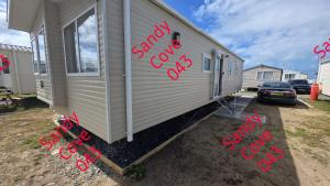 a mobile home with red writing on the side of it at Sandy cove 043 in Barmouth