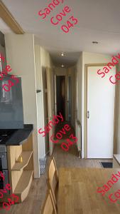 a room with a tv and a door with red letters at Sandy cove 043 in Barmouth