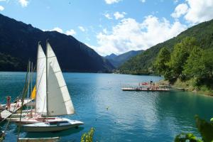 a couple of sailboats on a lake with a dock at Al Sole Apartment in Locca