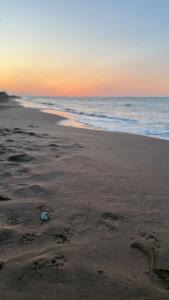 a beach with footprints in the sand and the ocean at Reverie Escape by Halisi in Ramsgate