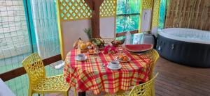 a table with a red and yellow checkered table cloth at Méline in Baie-Mahault