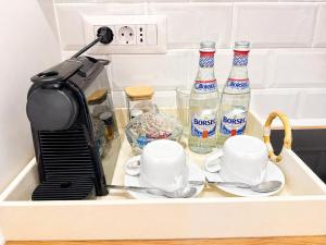a tray with two bottles of water and cups at A&K Apartament in Bacău