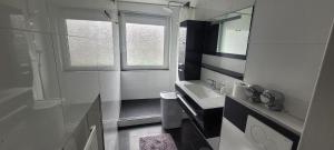 a white bathroom with a sink and a mirror at Ferienwohnung City in Nollingen +6 photos