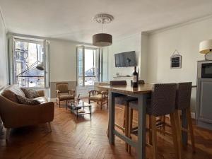 a living room with a table and chairs in it at L'Appart D'Oli et Tiane in Bordeaux