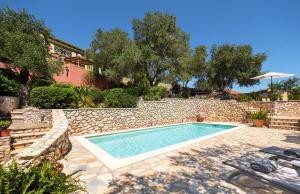 a swimming pool in a yard with a stone wall at Bay View Hotel in (( Klonátika )) +42 photos