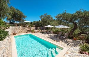 a swimming pool with two chairs and umbrellas at Bay View Hotel in (( Klonátika ))