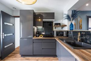 a kitchen with stainless steel appliances and a counter at Le 29 - T2 Calme - Confortable - Centre-ville in Valenciennes