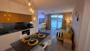 a kitchen and living room with a table and chairs at Golden Sun Apartment Grzybowo in Grzybowo