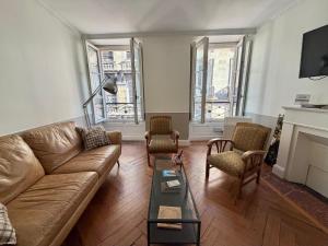 a living room with a couch and chairs and a fireplace at L'Appart D'Oli et Tiane in Bordeaux