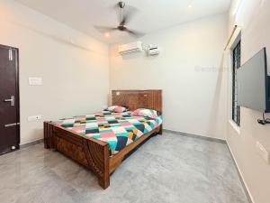 a bedroom with a bed and a flat screen tv at Sea shell in Covelong