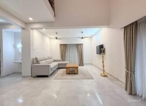 a living room with a couch and a table at Sea shell in Covelong