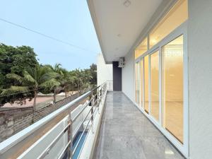 a balcony with a view of the beach and palm trees at Sea shell in Covelong