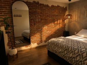 a bedroom with a brick wall and a mirror at Cabañas Boutiques TinyChillHouse in Mineral del Chico