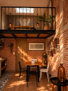 a room with a table and chairs and a brick wall at Cabañas Boutiques TinyChillHouse in Mineral del Chico