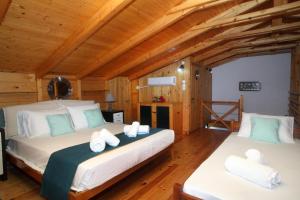 a bedroom with two beds in a log cabin at Villa Panorama in Kalamitsi