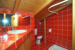 a red tiled bathroom with a toilet and a sink at Villa Panorama in Kalamitsi +12 photos