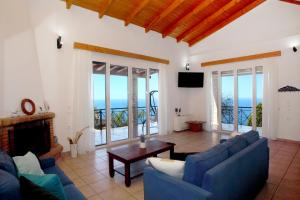 a living room with blue couches and a fireplace at Villa Panorama in Kalamitsi