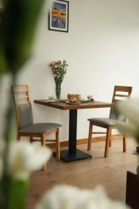 a table with two chairs and a vase of flowers on it at Dębowy Dwór, Wędkowanie, Stawy, Agroturystyka in Łagiewniki