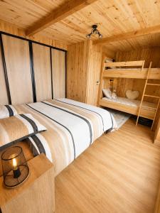 a bedroom with two beds in a wooden cabin at Le cocon beuillois in Beuil