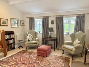 a living room with two chairs and a table at Blackmoor View Cottage in Sherborne