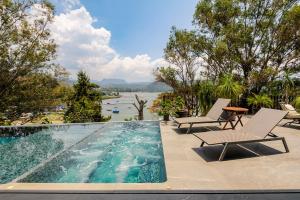 a swimming pool with two lounge chairs and a table at Villa del Carmen in Colorines