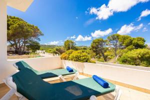 a balcony with two lounge chairs and a view of trees at Villa Elena Dorada in Port d'Addaia