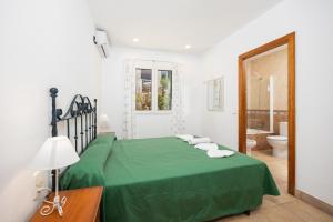 a bedroom with a green bed and a bathroom at Villa Elena Dorada in Port d'Addaia +23 photos