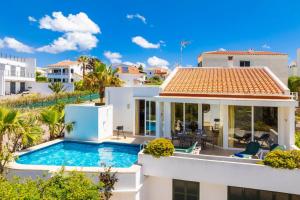 a villa with a swimming pool in front of a house at Villa Elena Dorada in Port d'Addaia