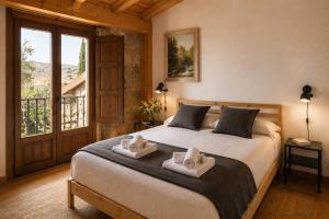 a bedroom with a large bed with towels on it at Casa Luenga in Vinuesa