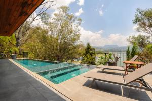 a swimming pool with two chairs and a table at Villa del Carmen in Colorines