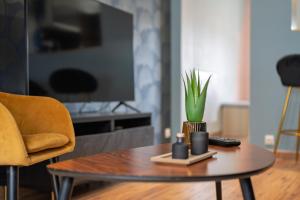 a living room with a table with a plant on it at Le 29 - T2 Calme - Confortable - Centre-ville in Valenciennes