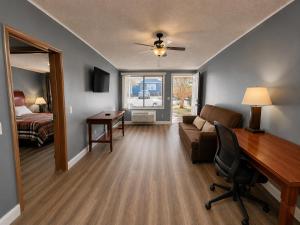 a living room with a desk and a couch and a bed at Sunwestern Suites in Douglasville