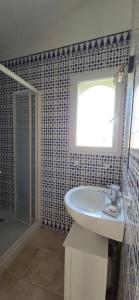 a bathroom with a sink and a window and a shower at Casa Esperanto in Béziers