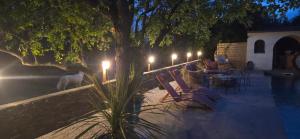 a group of chairs and tables with lights next to a pool at Casa Esperanto in Béziers +10 photos