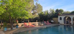 a group of chairs sitting next to a swimming pool at Casa Esperanto in Béziers