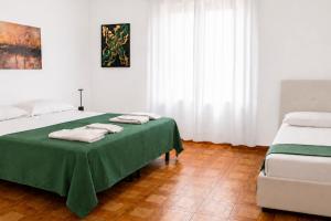 a bedroom with two beds with towels on a table at Appartamenti ABR Porto in Le Castella