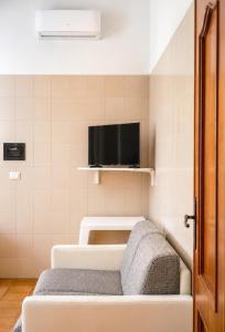 a room with a couch and a tv on a wall at Appartamenti ABR Porto in Le Castella