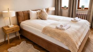 a bedroom with a bed with towels on it at Greystone Suites & Apartments in Riga