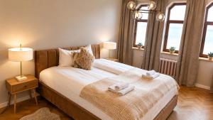 a bedroom with a bed with towels on it at Greystone Suites & Apartments in Riga