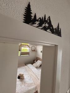 a bedroom with a bed and trees on the wall at Chez Baron in Hauterive