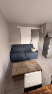 a living room with a blue couch and a table at Appartement 2 Pièces in Annemasse